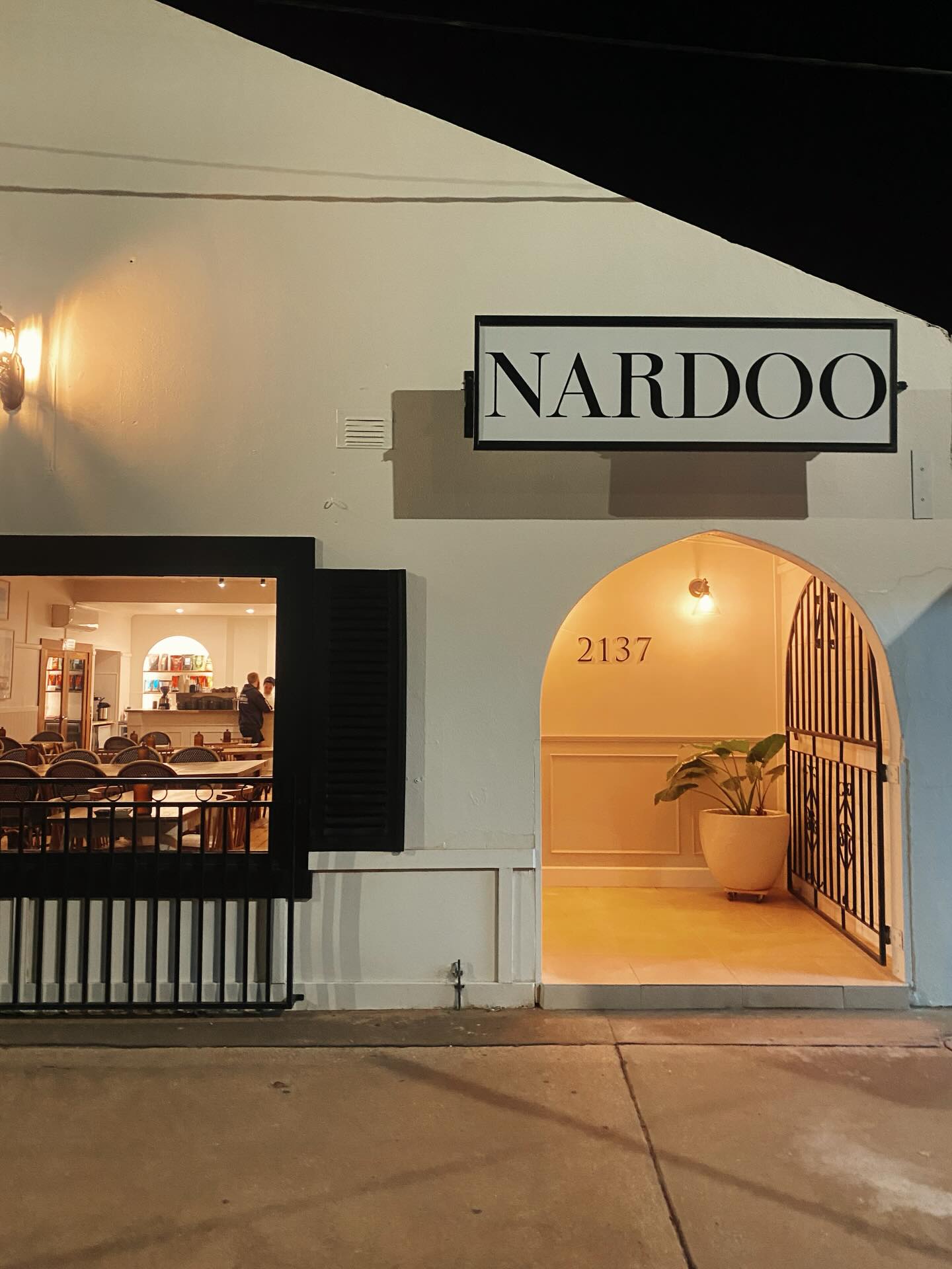 The Nardoo building at night, arch entrance lit warm